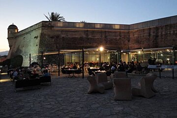 chairs and outdoor bar with castle walls in background