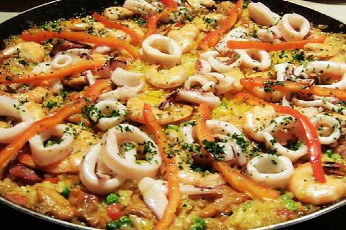 A pan filled with a variety of seafood and vegetables