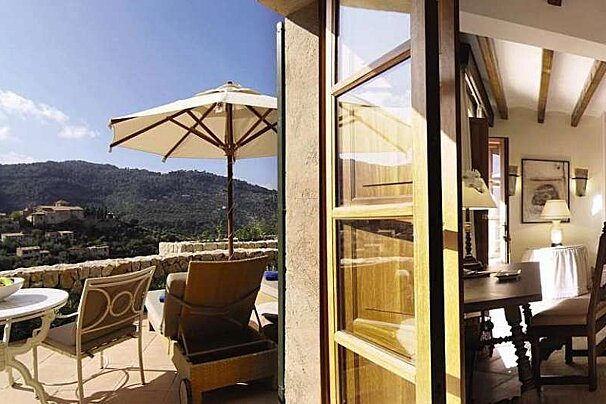 an image of a luxury hotel suite with a terrace overlooking the hills