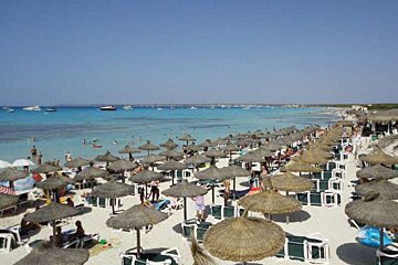 Parasols on beach with blue water