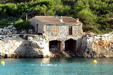 a photo of a fishing cottage and the sea in mondrago majorca