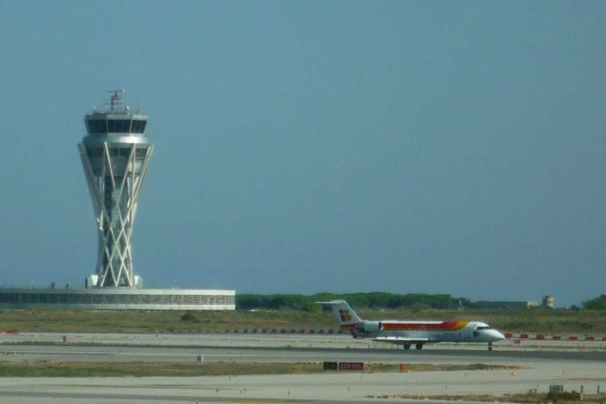 a photo of a plane and the airport control tower