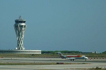 a photo of a plane and the airport control tower