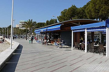 a photo of a paved path by the beach