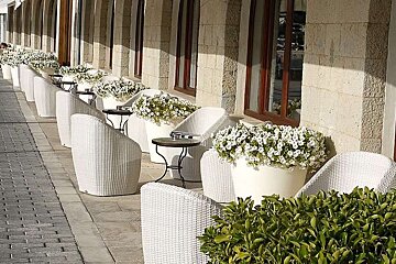 photo of a pavement cafe with white chairs and white flowers