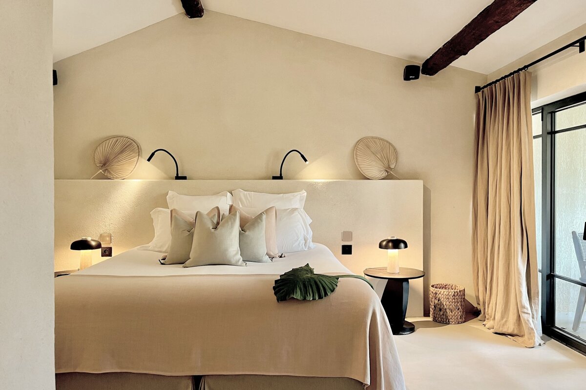 A bedroom with a bed and two lamps on the wall