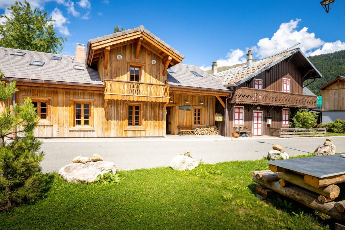 A wooden house with a sign that says ' l' ermitage ' on it