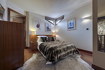 A bedroom with a bed and two paintings on the wall one of which says david platt