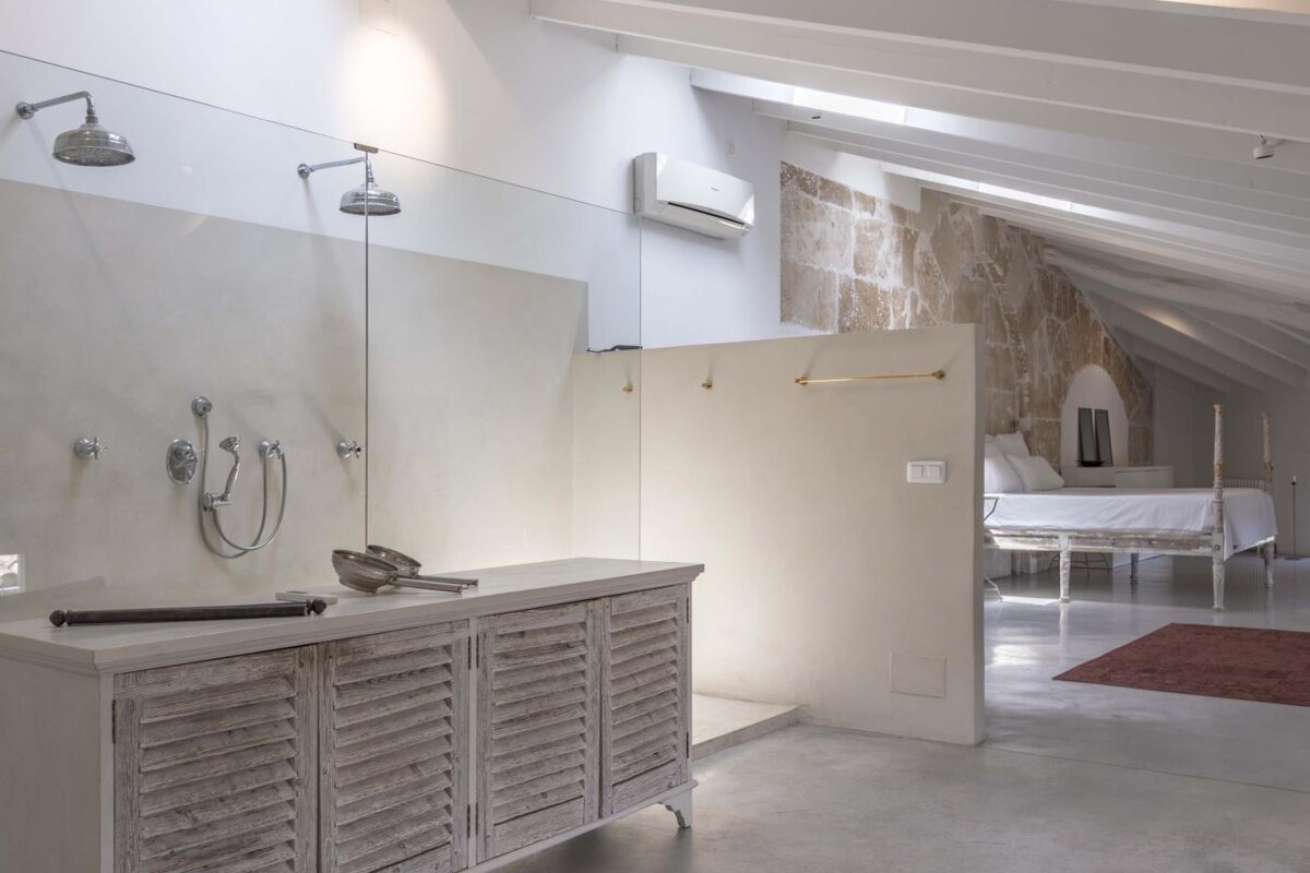 A bathroom with a walk in shower and a bed