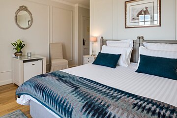 A hotel room with a bed and a picture on the wall
