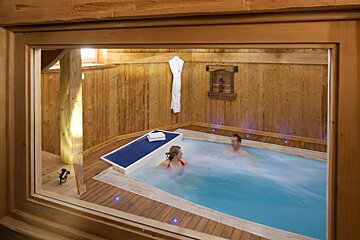 A man and a woman are in a swimming pool