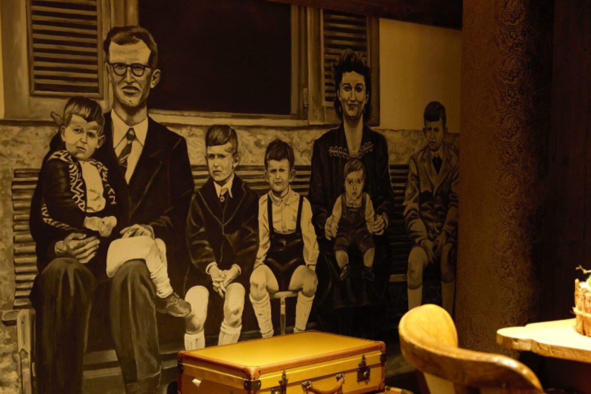 A black and white painting of a family sitting on a bench