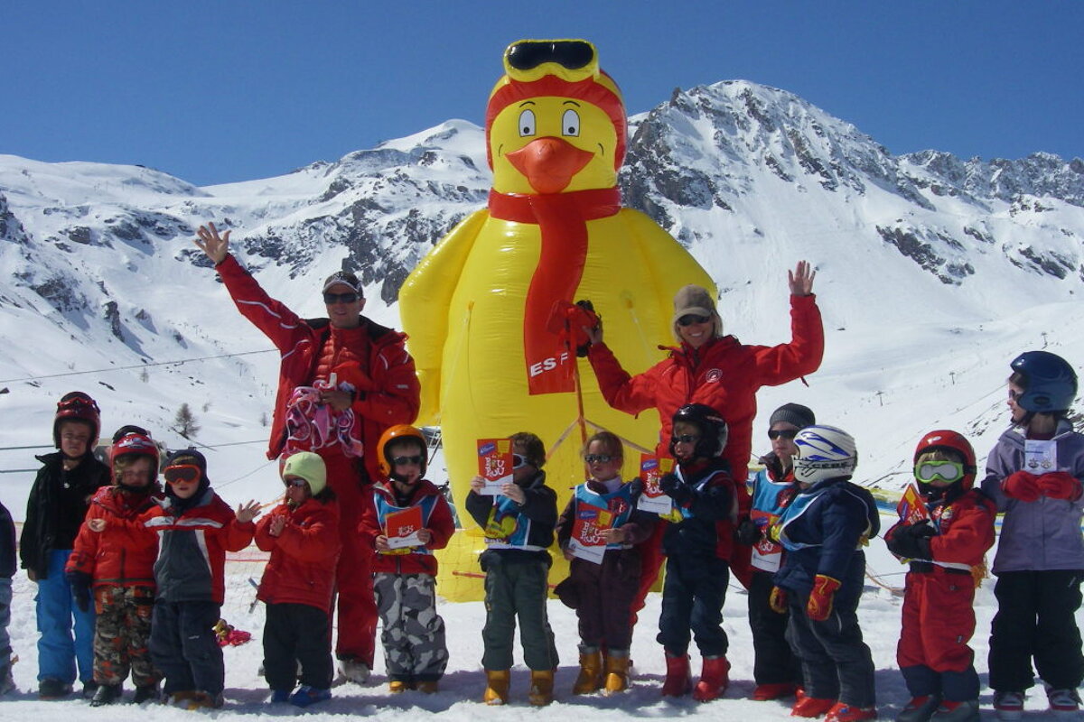 A group of children standing in front of an inflatable chicken that says esf
