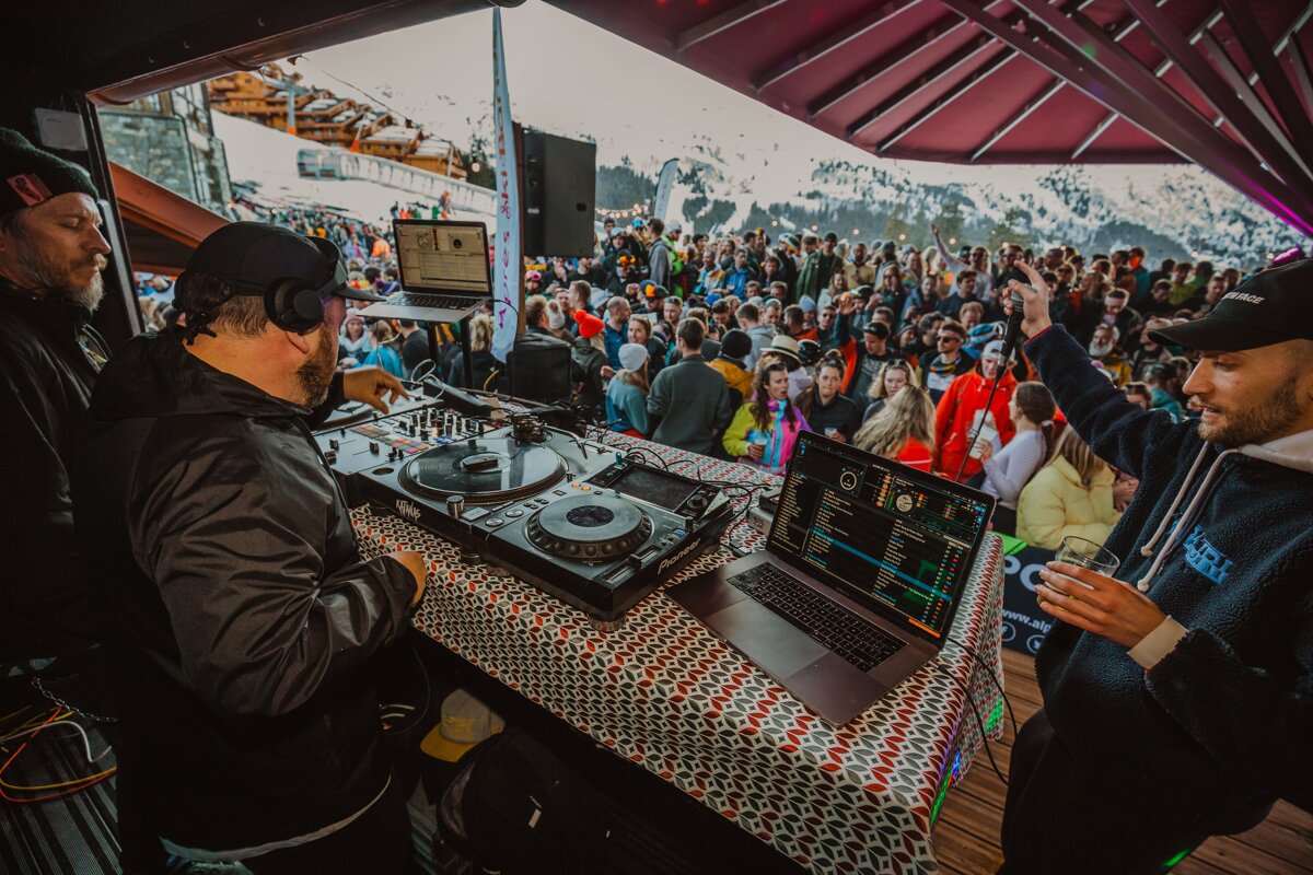 A dj playing music in front of a crowd wearing a hoodie that says ' abercrombie & fitch ' on it