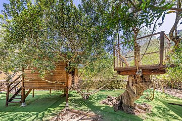 A tree house with a hammock attached to it
