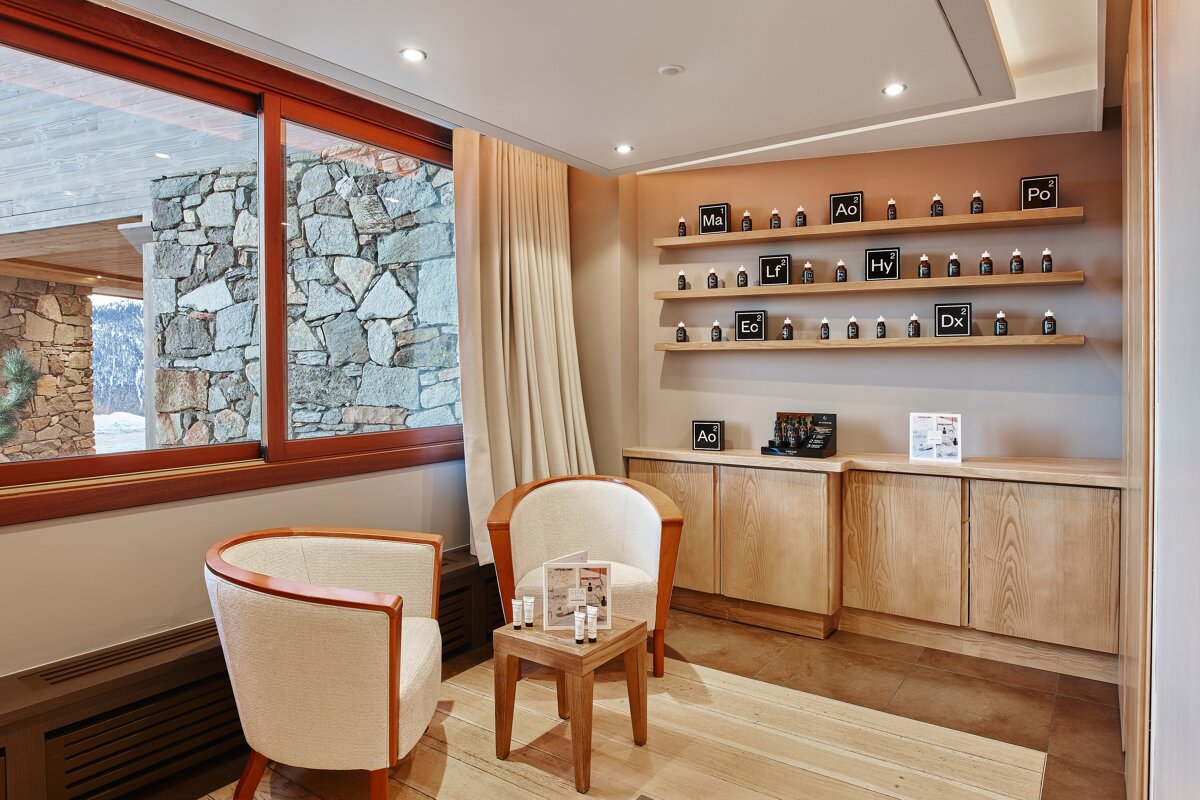 A room with two chairs and a shelf full of bottles with the letters ao on them