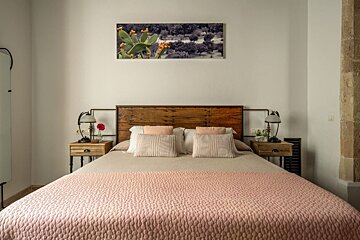 A bed with a wooden headboard and a pink blanket