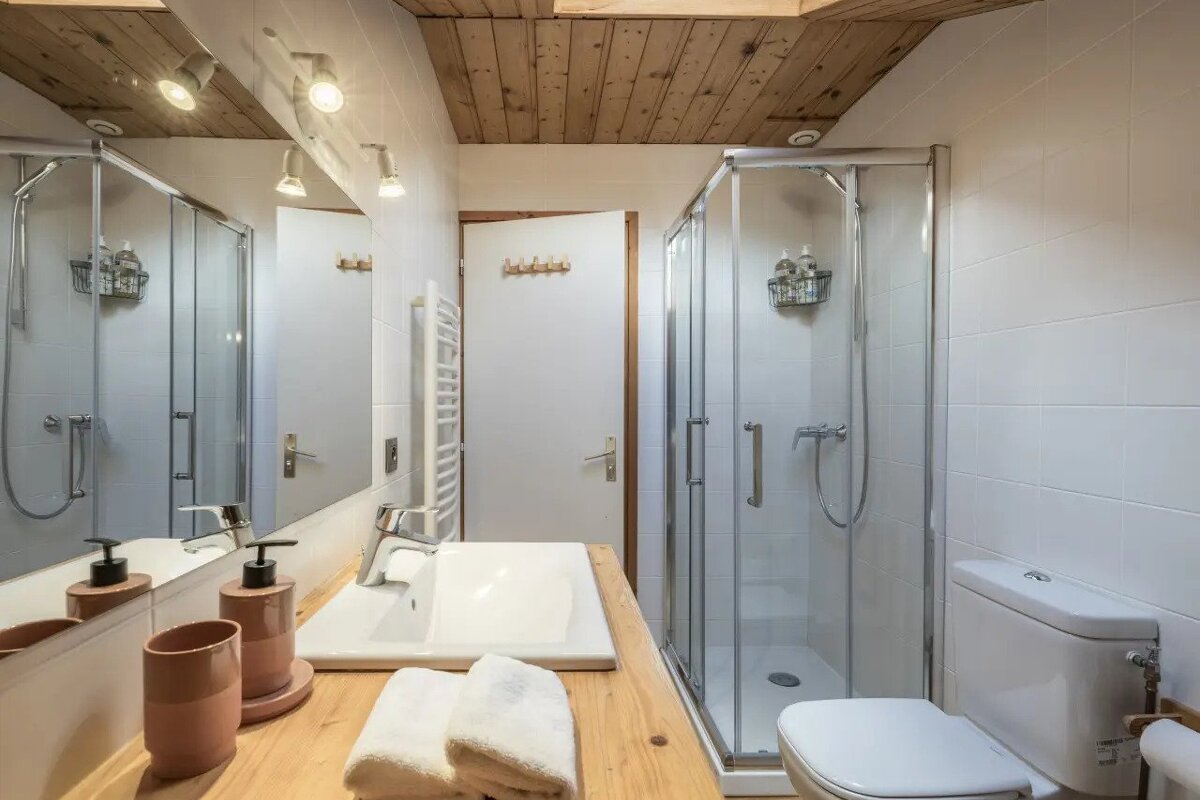 A bathroom with a toilet a sink and a shower