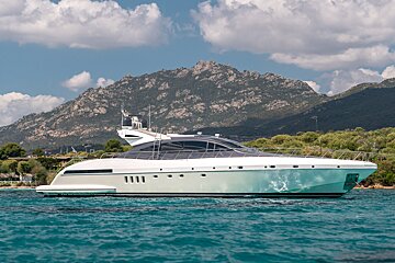 A large yacht is floating in the ocean with a mountain in the background