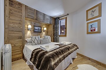 A bedroom with a bed and a picture of a ski lift on the wall