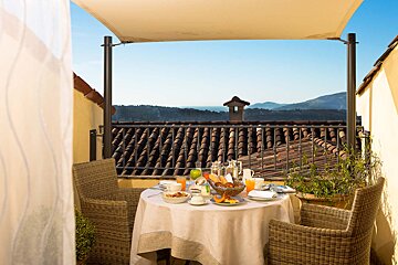 A balcony with a table and chairs and a view of the mountains
