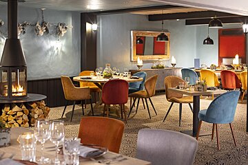A restaurant with tables and chairs and a fireplace