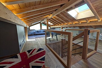 A wooden staircase with a british flag chair in the foreground