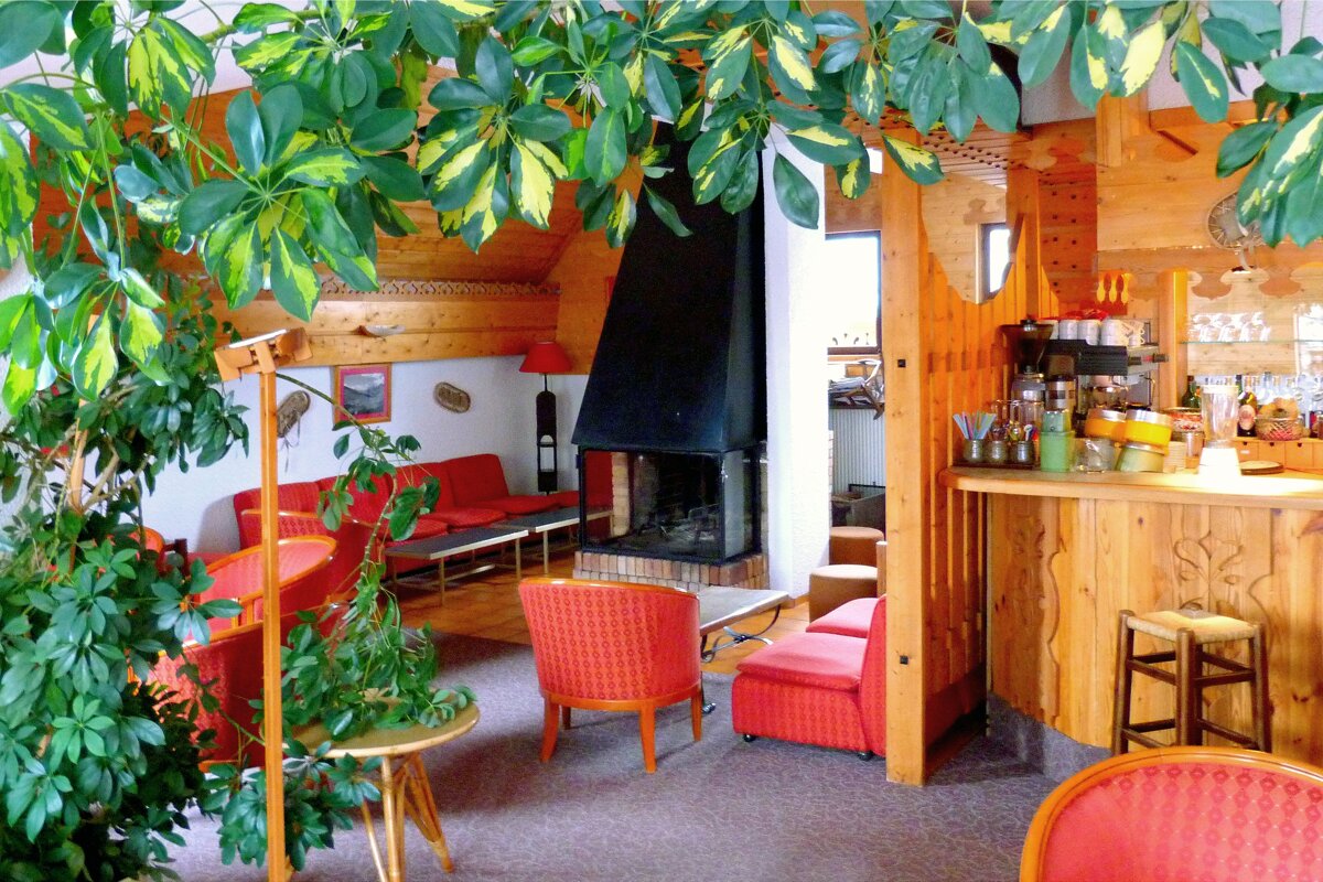 A living room with red chairs and a fireplace