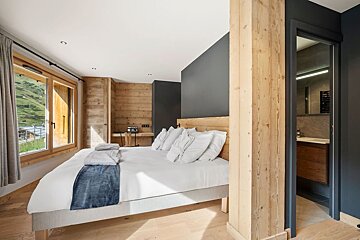 A bedroom with a large bed and a window