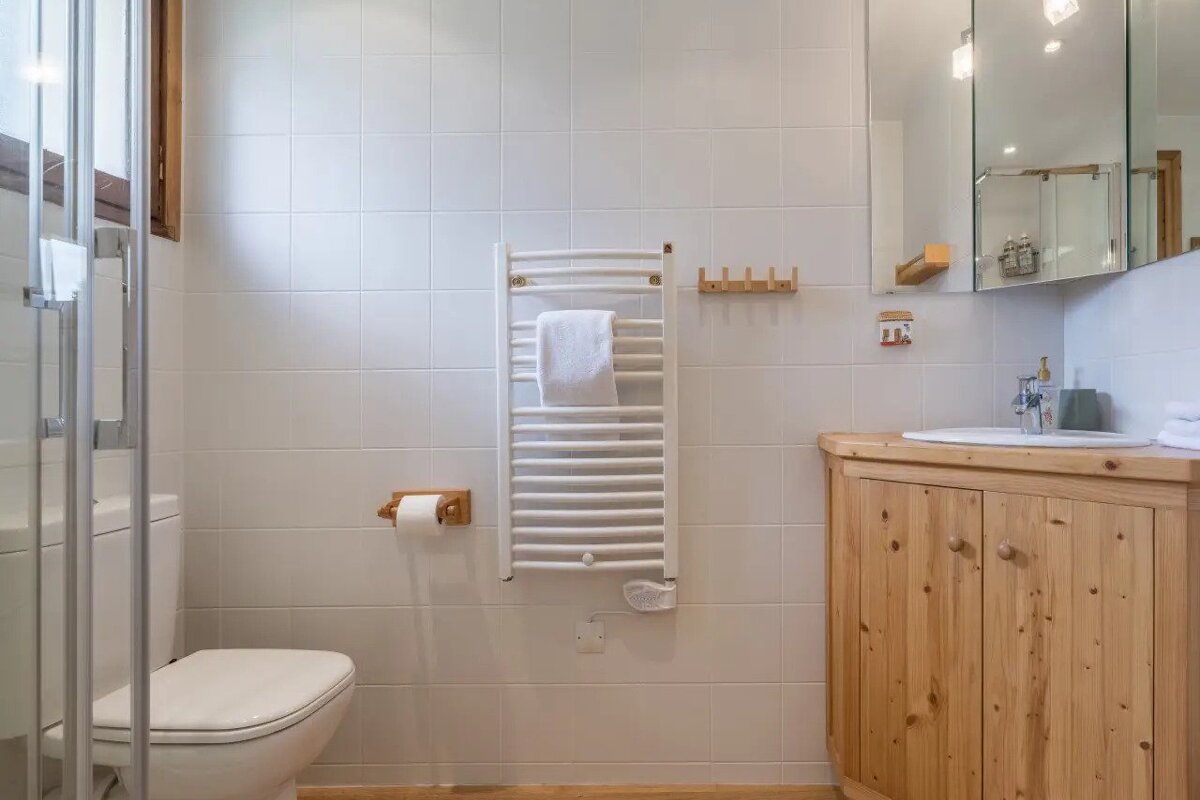 A bathroom with a toilet a sink and a towel rack