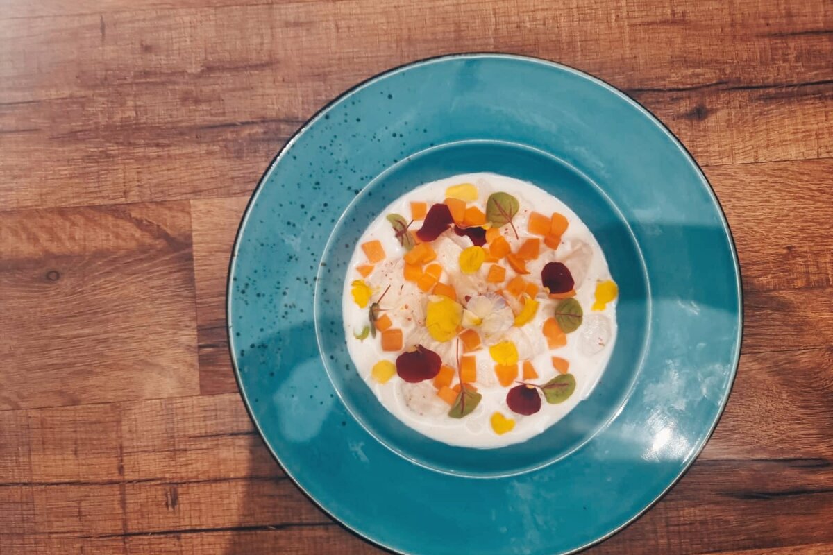 A blue plate with a bowl of soup on it