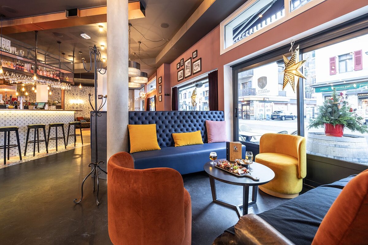 A restaurant with a blue couch and yellow pillows