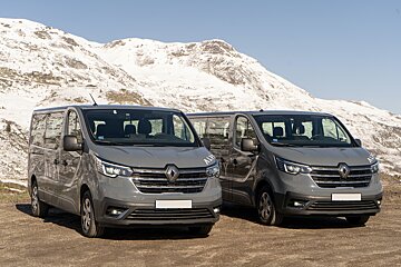 Two renault vans are parked in front of a snowy mountain