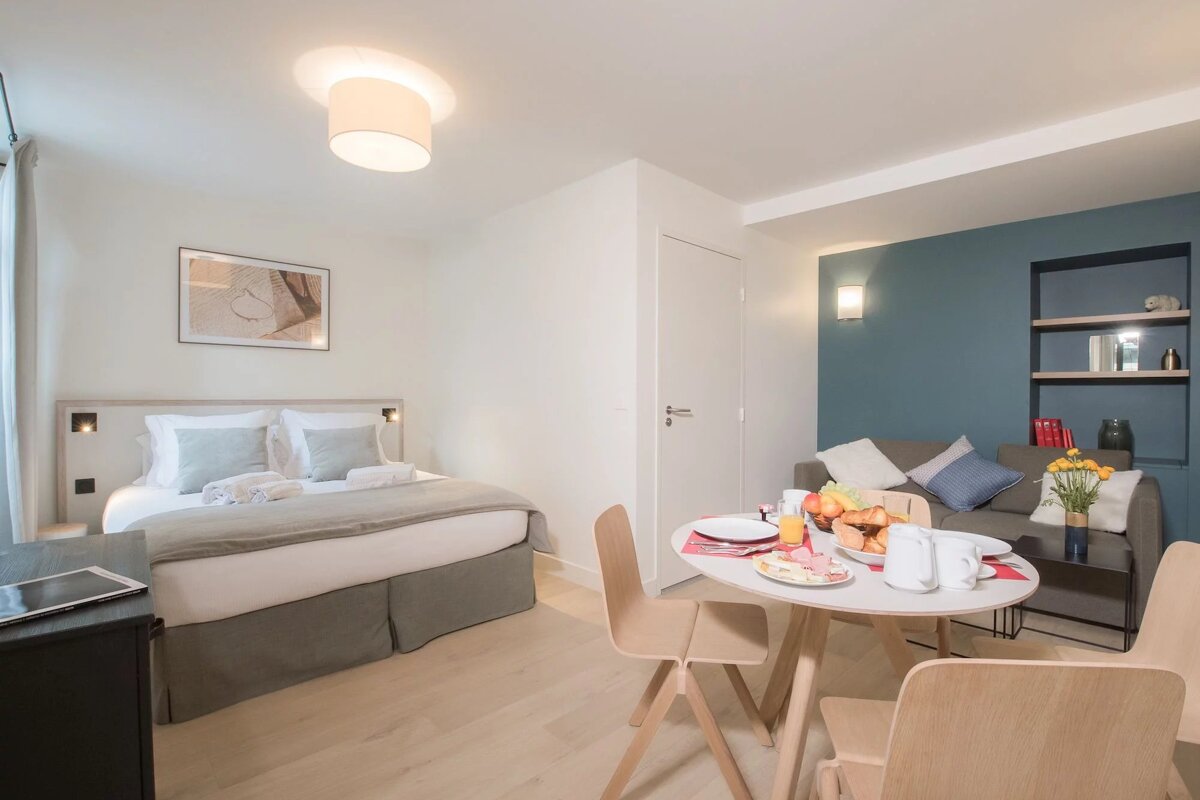 A hotel room with a bed and a table with food on it