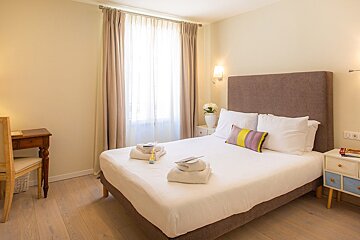 A bedroom with a large bed and a desk