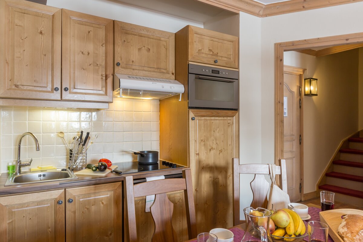 A kitchen with wooden cabinets and a stove top oven