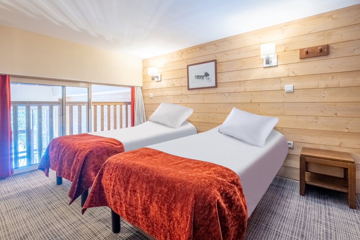 A bedroom with two twin beds and a picture on the wall