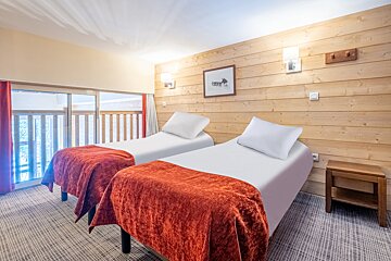A bedroom with two twin beds and a picture on the wall