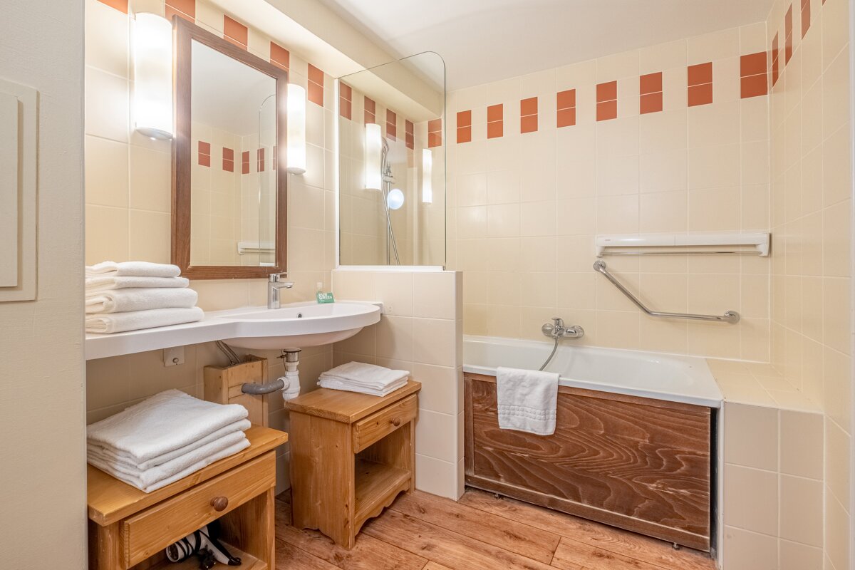 A bathroom with a sink a mirror and a bathtub