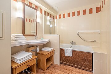 A bathroom with a sink a mirror and a bathtub