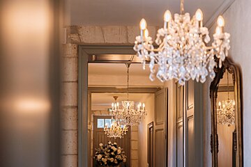 A hallway with many chandeliers hanging from the ceiling