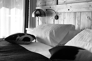 A black and white photo of a hotel bed