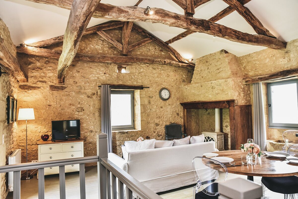 A living room with a white couch and a clock on the wall