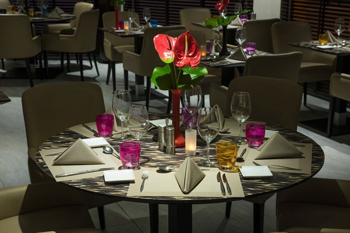 A table set for a dinner with a vase of flowers on it