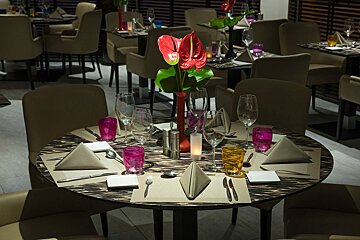 A table set for a dinner with a vase of flowers on it
