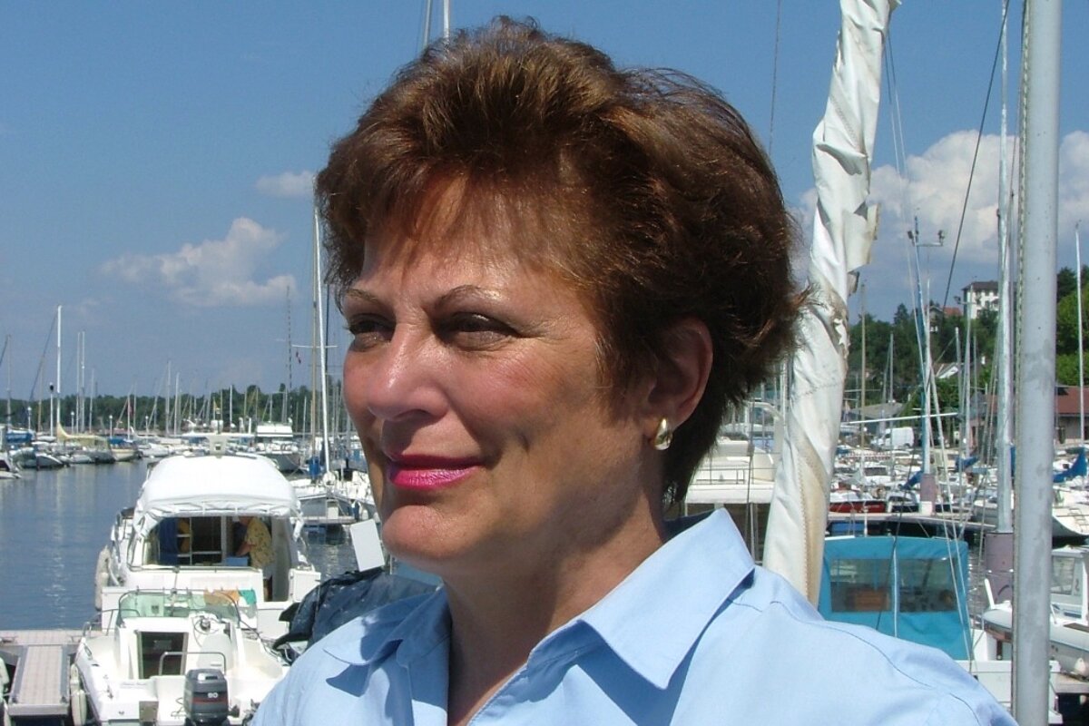a woman in a blue shirt at a marina