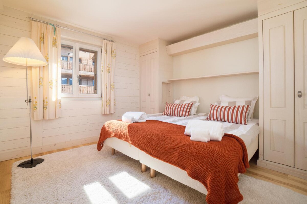 A bedroom with two beds and a lamp