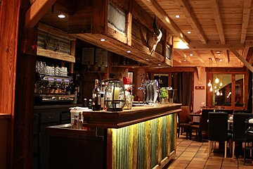 A bar in a restaurant with a bottle of wine on it
