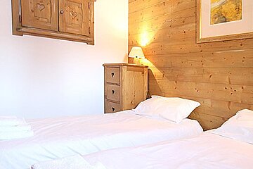 A bedroom with two beds and a picture on the wall