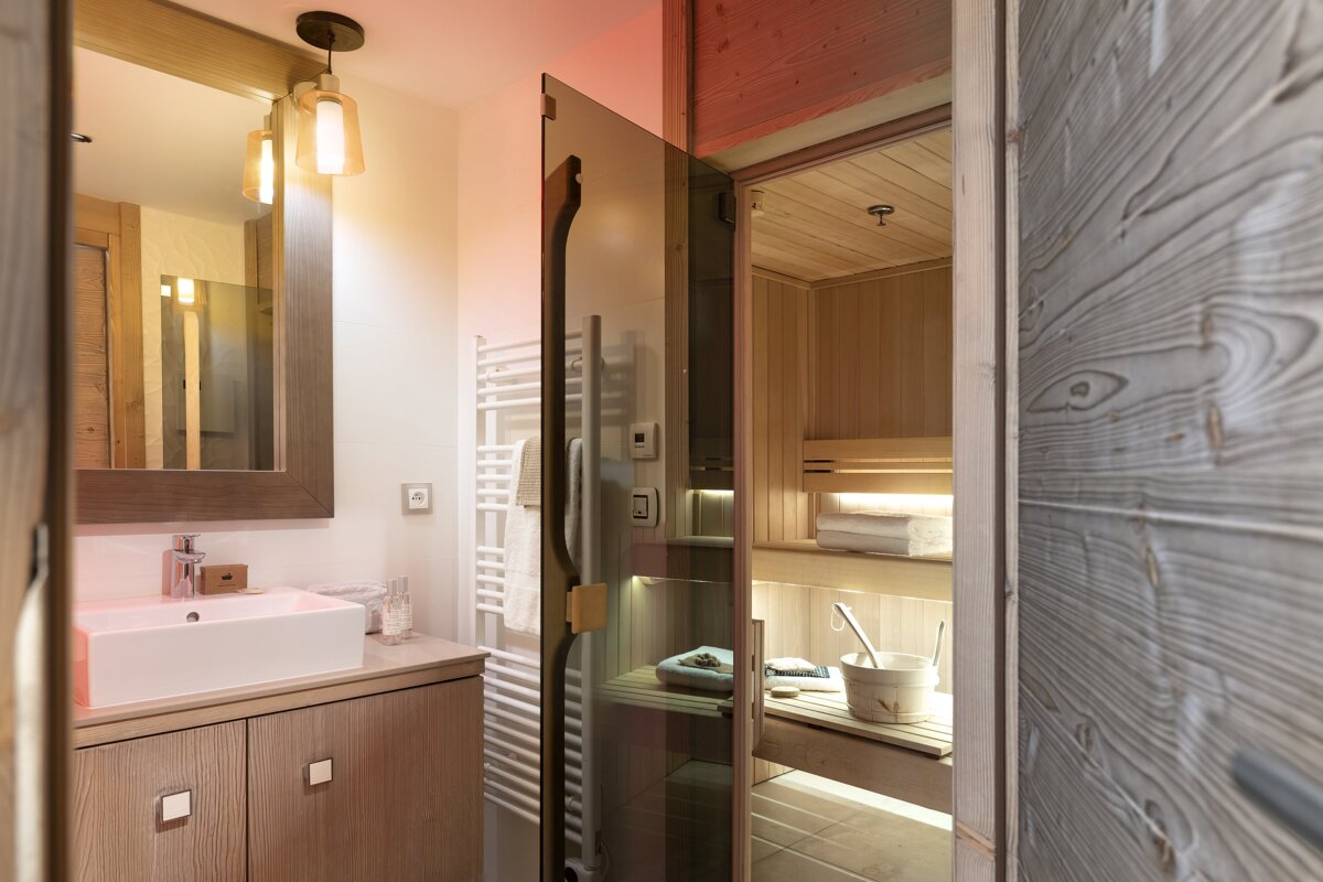 A bathroom with a sink a mirror and a sauna